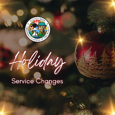 A photo of an ornament in a Christmas tree with clear lights, detailing the holiday service changes.