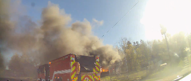 A Battle Creek Fire Department vehicle responds to a scene with a large plume of black smoke.